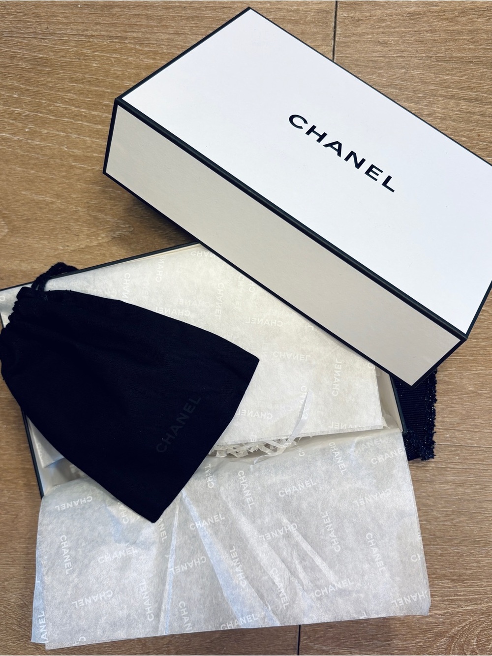 White Chanel gift box with navy blue logo ribbon and Chanel drawstring pouch